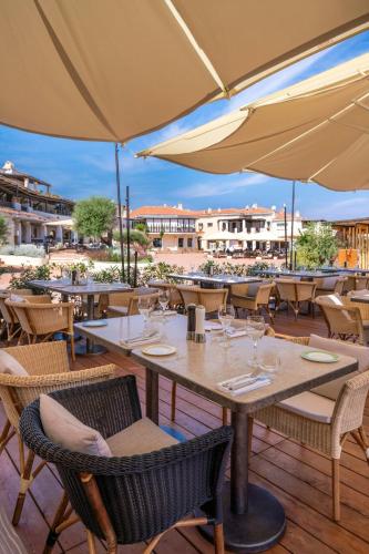 a restaurant with tables and chairs with umbrellas at Cervo Hotel,Costa Smeralda Resort in Porto Cervo