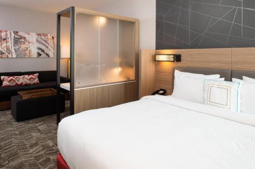 a hotel room with a large bed and a couch at SpringHill Suites by Marriott Kansas City Northeast in Kansas City