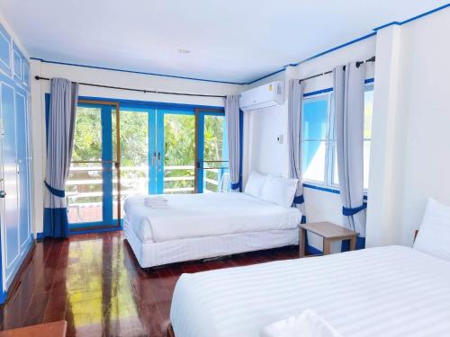 two beds in a room with two windows at THE SKY EXCLUSIVE VILLA Bluesky in Ban Tha Sai