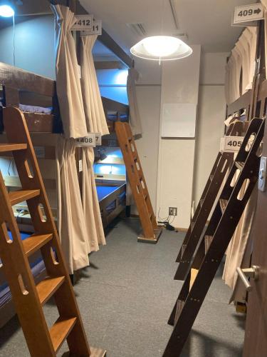 a room filled with lots of wooden bunk beds at Hostel Lodging Tokyo Ueno in Tokyo