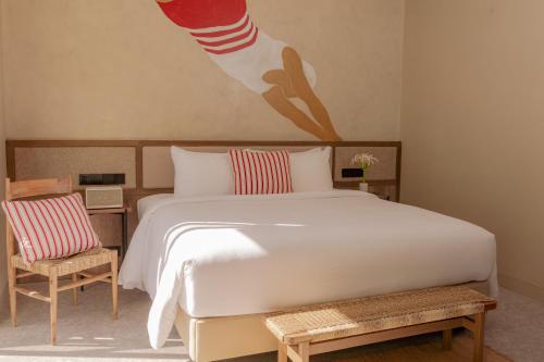 a bedroom with a large white bed and two chairs at Soul Boutique Hotel Phu Quoc in Phu Quoc