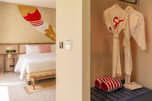 a hotel room with a bed and some clothes on racks at Soul Boutique Hotel Phu Quoc in Phu Quoc
