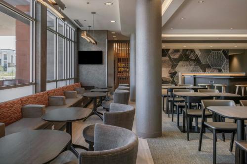 a restaurant with tables and chairs and a bar at SpringHill Suites by Marriott Phoenix West/Avondale in Avondale