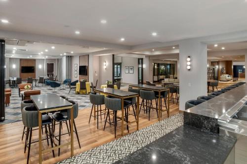a lobby with tables and chairs in a building at Sheraton Suites Old Town Alexandria in Alexandria