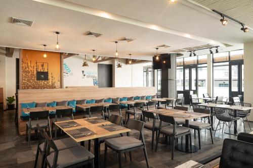 a dining room with wooden tables and chairs at Cross Vibe Bangkok Sukhumvit in Bangkok