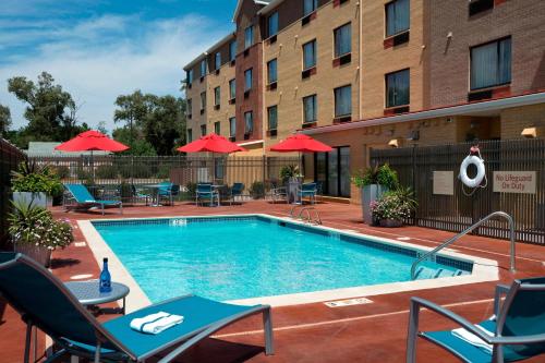 a pool at a hotel with chairs and umbrellas at TownePlace Suites by Marriott Garden City in Garden City