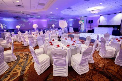 a banquet hall with white tables and white chairs at Sheraton Niagara Falls in Niagara Falls