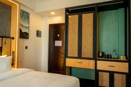 a bedroom with a bed and a wooden cabinet at Athiri Residence in Dhiffushi