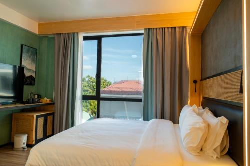 a bedroom with a bed and a large window at Athiri Residence in Dhiffushi