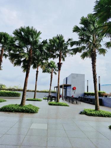 a row of palm trees and a building with tables and chairs at Luxury Accommodation Trio Bukit Tinggi in Klang