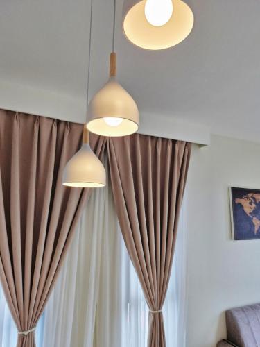 two lights hanging over a window with curtains at Luxury Accommodation Trio Bukit Tinggi in Klang