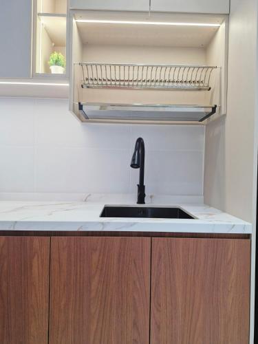 a kitchen counter with a sink and a mirror at Luxury Accommodation Trio Bukit Tinggi in Klang