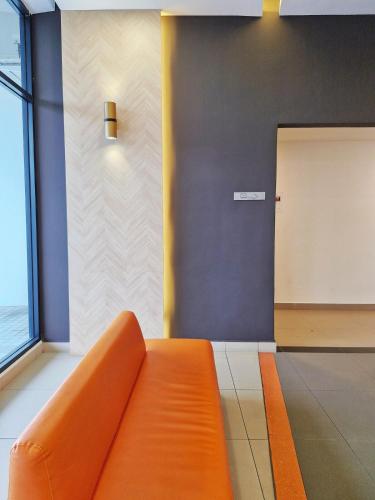 an orange couch in a room with a door at Luxury Accommodation Trio Bukit Tinggi in Klang