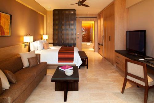 a hotel room with a bed and a couch at JW Marriott Los Cabos Beach Resort & Spa in San José del Cabo