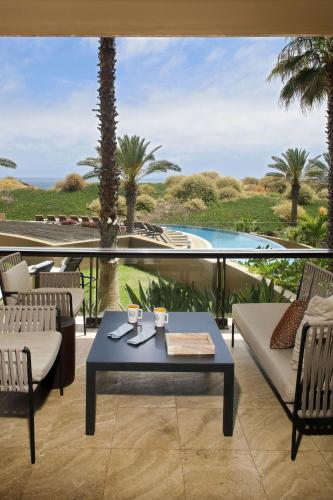 a patio with a table and chairs and a pool at JW Marriott Los Cabos Beach Resort & Spa in San José del Cabo