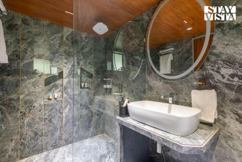 a bathroom with a sink and a mirror at StayVista's Esperanza - Mountain-Side Retreat with Infinity Pool, Jacuzzi, Gazebo & Indoor-Outdoor Activities in Lonavala