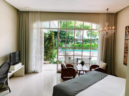 Un dormitorio con una cama y una ventana grande. en Casa Artista By Kresna Hospitality, en Seminyak
