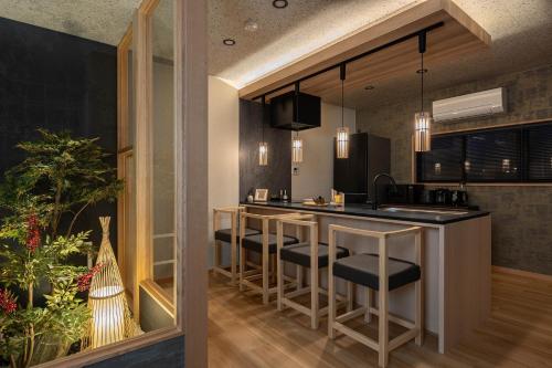 a kitchen with a bar with stools at JAPAVISTA Maverique in Osaka