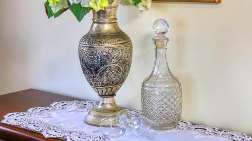 two glass vases sitting on a table next to a bottle at Birchwood on the River - Devonport, Tasmania - Self-Contained and Self-Catering Accommodation in Devonport