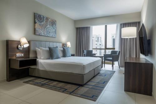 a hotel room with a bed and a desk with a chair at Residence Inn by Marriott Algiers Bab Ezzouar in Alger