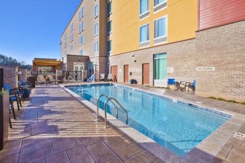 a swimming pool with chairs next to a building at SpringHill Suites by Marriott Chattanooga North/Ooltewah in Ooltewah