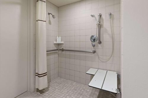 a bathroom with a shower with a bench in it at Travelodge by Wyndham Monterey Bay in Monterey