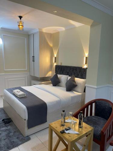 a bedroom with a bed and a table and a chair at Bijou Hotel in Nairobi