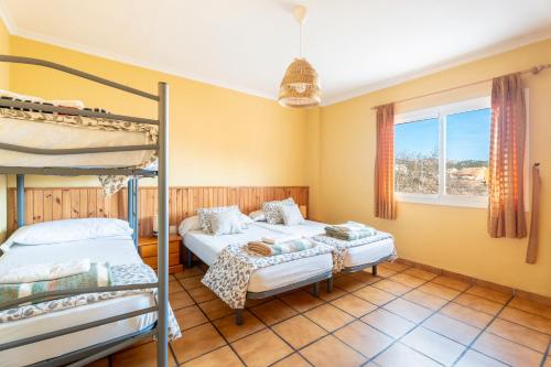 ein Schlafzimmer mit zwei Etagenbetten und einem Fenster in der Unterkunft La Casona in Chera