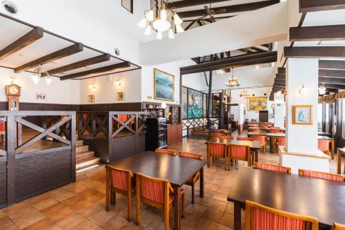 a restaurant with wooden tables and chairs and a bar at Hotel Jogakura in Aomori
