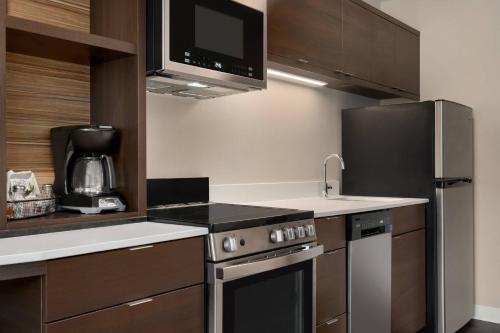 a kitchen with a stove and a refrigerator at TownePlace Suites by Marriott Logan in Logan