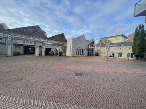an empty parking lot in front of a building at Suite With Wellness Nextdoor And Kitchen Access in Oss