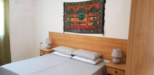 a bedroom with a bed with a tapestry on the wall at Farmhouse on an olive grove in Siġġiewi