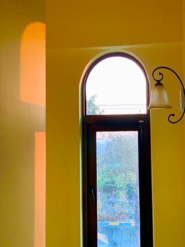 a window in a room with a yellow wall at Villa San Diego in Puli