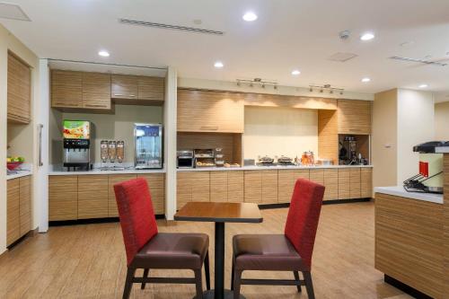 a kitchen with a table and two chairs and a counter at TownePlace Suites by Marriott McAllen Edinburg in Edinburg