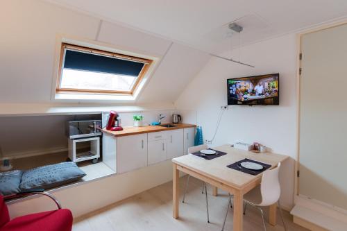 a room with a table and a kitchen with a window at 7even in Vrouwenpolder