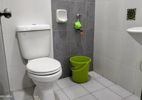 La salle de bains est pourvue de toilettes et d'une poubelle verte. dans l'établissement IRIS 33 Corner Lot House Spacious Outdoor Malay Only, à Skudai