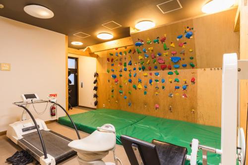a room with a rock wall with a climbing wall at Hotel Jogakura in Aomori