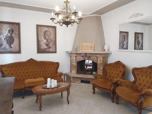 a living room with chairs and a fireplace at Grande Appartamento in Villa con 2 camere, terrazze, giardino, barbecue e posto auto privato Tutti spazi uso esclusivo in Cecina