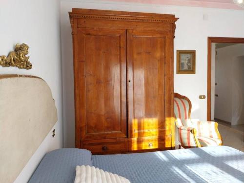 a wooden cabinet in a bedroom with a bed at Grande Appartamento in Villa con 2 camere, terrazze, giardino, barbecue e posto auto privato Tutti spazi uso esclusivo in Cecina