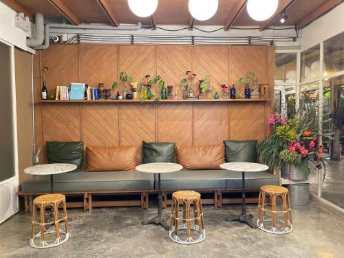 a couch in a room with two tables and stools at GalileOasis Boutique Hotel in Bangkok