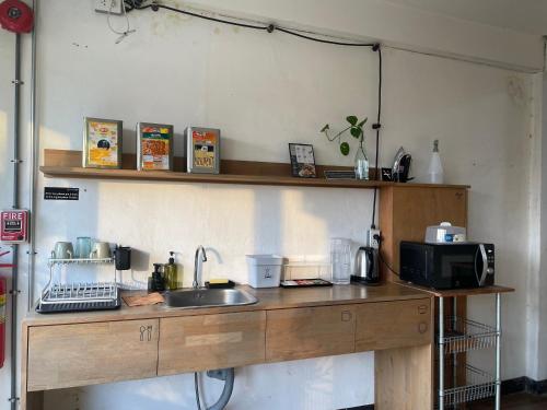 a kitchen counter with a sink and a microwave at GalileOasis Boutique Hotel in Bangkok