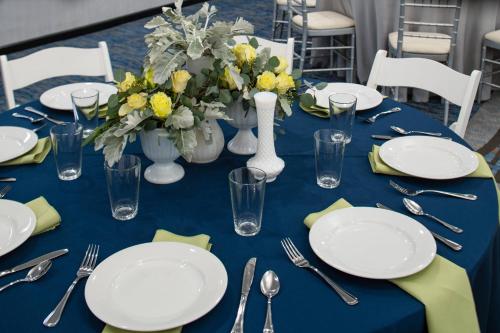 a blue table with white plates and vases with flowers at TownePlace by Marriott Suites Clarksville in Clarksville