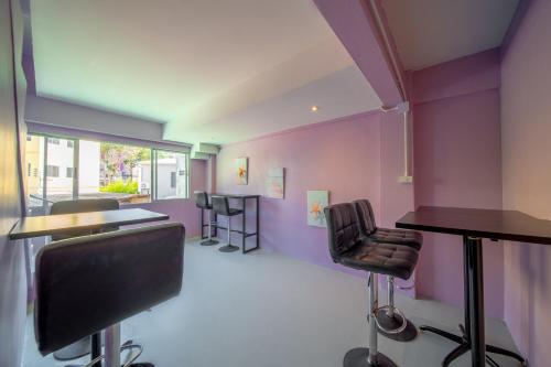 a salon with purple walls and two barber chairs at UrbanNest Hostel in Pattaya
