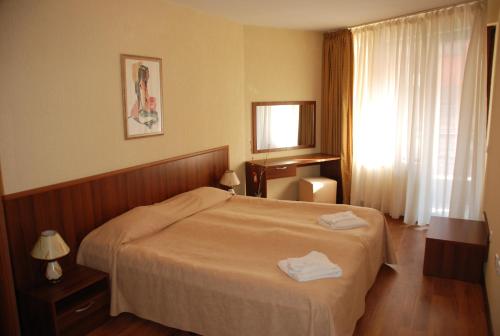 a bedroom with a bed with two towels on it at Apart Hotel Comfort in Bansko