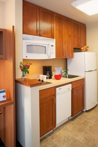 a kitchen with white appliances and wooden cabinets at TownePlace Suites Medford in Medford