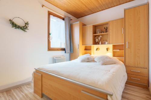 - une chambre avec un grand lit et des placards en bois dans l'établissement La Cime des 4 - Vue sur la vallée à La Bresse, à La Bresse