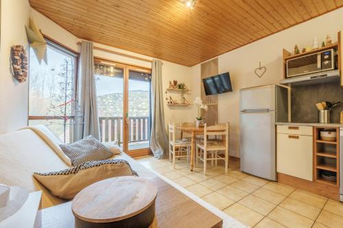 un salon avec une cuisine et une table dans l'établissement La Cime des 4 - Vue sur la vallée à La Bresse, à La Bresse