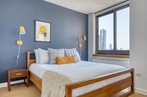 a bedroom with a bed with blue walls and a window at Tribeca Studio w Gym Indoor pool NYC-184 in New York