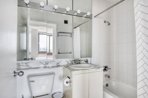 a white bathroom with a sink and a mirror at Tribeca Studio w Gym Indoor pool NYC-184 in New York