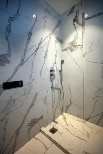 a bathroom with a marble wall with a phone at OPO Iffco Chowk, Gurgaon in Gurgaon